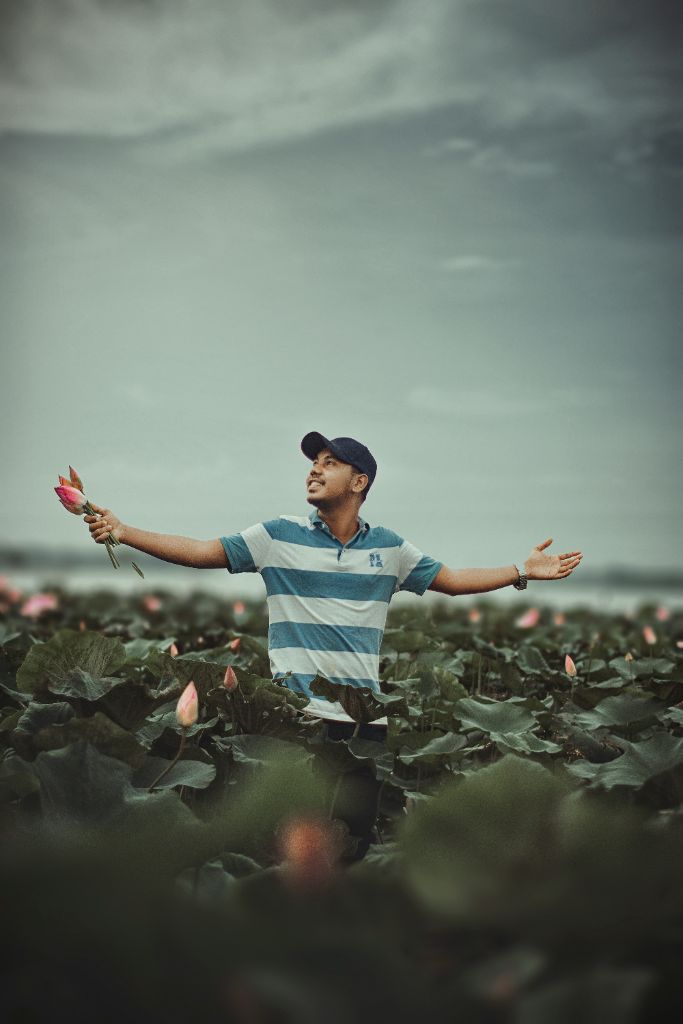Man with arms outstretched in a lotus field